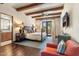 The main bedroom features wood floors, beamed ceiling, adjoining bathroom and seating area with an orange armchair at 18683 N 101St Pl, Scottsdale, AZ 85255