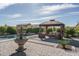 This beautifully landscaped backyard features a fountain and a covered seating area at 18811 W San Miguel Ave, Litchfield Park, AZ 85340