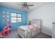 Charming bedroom featuring bright blue accent wall, a large window, and playful decor creating a cheerful atmosphere at 18811 W San Miguel Ave, Litchfield Park, AZ 85340