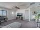 This light and bright bonus room features a ceiling fan, grey carpet, and a work space at 18811 W San Miguel Ave, Litchfield Park, AZ 85340