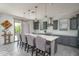 Modern eat-in kitchen featuring pendant lighting, bar stool seating, and gray cabinets at 18811 W San Miguel Ave, Litchfield Park, AZ 85340