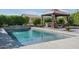 Relaxing backyard pool area featuring a covered seating area and lush landscaping offering a serene outdoor space at 18811 W San Miguel Ave, Litchfield Park, AZ 85340