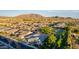 An aerial view of a charming neighborhood showcasing beautiful homes, lush greenery, and scenic mountain views at 1925 E La Costa Dr, Gilbert, AZ 85298