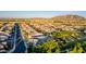 An aerial view showcasing a neighborhood with well-maintained homes, mature trees, and a community basketball court at 1925 E La Costa Dr, Gilbert, AZ 85298