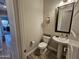 Powder room with pedestal sink, toilet, decorative mirror, and wood-look tile flooring at 1925 E La Costa Dr, Gilbert, AZ 85298