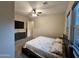 Sunlit carpeted bedroom featuring ceiling fan, flat-screen TV, and updated windows for ample natural light at 1925 E La Costa Dr, Gilbert, AZ 85298