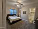 A cozy carpeted bedroom features a full-sized bed, ceiling fan, and an ensuite bathroom at 1925 E La Costa Dr, Gilbert, AZ 85298