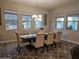 Bright dining room featuring a modern chandelier, a large wooden table, and views to the backyard at 1925 E La Costa Dr, Gilbert, AZ 85298