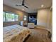 Spacious carpeted main bedroom with sitting area, ceiling fan, and flat-screen TV above a gray console at 1925 E La Costa Dr, Gilbert, AZ 85298