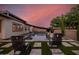 Inviting pool area with lounge chairs, lush landscaping, and ambient lighting for outdoor relaxation at 1925 E La Costa Dr, Gilbert, AZ 85298