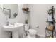 Elegant powder room with a pedestal sink and decorative shelving at 19919 W Harrison St, Buckeye, AZ 85326