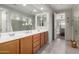 Bathroom with double sinks, wood cabinets, and a large mirror at 19919 W Harrison St, Buckeye, AZ 85326