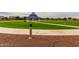 Community gazebo surrounded by green space, sidewalks, and green grass at 19919 W Harrison St, Buckeye, AZ 85326