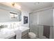 Updated bathroom with framed mirror, glass-enclosed shower, and quartz countertop at 2016 N Pennington Dr, Chandler, AZ 85224