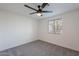 A well-lit bedroom featuring gray carpet, a ceiling fan, and a window at 2016 N Pennington Dr, Chandler, AZ 85224