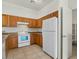 Functional kitchen with oak cabinets, white appliances, and tile floors, offering ample storage at 2150 E Bell Rd # 1134, Phoenix, AZ 85022