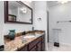 Bathroom featuring granite countertops, designer mirror, and soft lighting, creating a luxurious and inviting atmosphere at 2169 E Alameda Dr, Tempe, AZ 85282