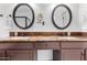 Bathroom featuring a double vanity, granite counters, mosaic backsplash, and round mirrors for a classic aesthetic at 2169 E Alameda Dr, Tempe, AZ 85282