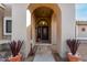 Welcoming arched entryway with a detailed front door and decorative potted plants at entrance at 2169 E Alameda Dr, Tempe, AZ 85282