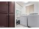 Functional laundry room with white washer and dryer, closet, storage shelves, and a window at 2169 E Alameda Dr, Tempe, AZ 85282