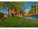 Lush green lawn with mature landscaping and a secure pool fence surrounds the home at 2633 E Amber Ridge Way, Phoenix, AZ 85048