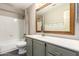 Bathroom with white tiling, gray cabinets, stylish mirror, and neutral walls at 2633 E Amber Ridge Way, Phoenix, AZ 85048