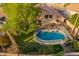 Aerial view of backyard pool with grassy area, patio, and safety fence at 2633 E Amber Ridge Way, Phoenix, AZ 85048