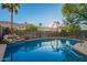 Backyard swimming pool with rock waterfall feature, surrounded by desert landscaping and a safety fence at 2633 E Amber Ridge Way, Phoenix, AZ 85048