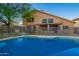 Backyard swimming pool with security fence, set against a stucco two-story home, and desert landscaping at 2633 E Amber Ridge Way, Phoenix, AZ 85048