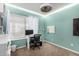 Bedroom with turquoise walls, white trim and modern ceiling fan and lights, a large window, and a desk at 2744 E Windrose Dr, Phoenix, AZ 85032