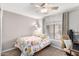 Cozy bedroom features a floral quilt, ceiling fan and light with a workspace near the bright window at 2744 E Windrose Dr, Phoenix, AZ 85032