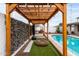 Poolside pergola featuring a unique design with string lights, artificial turf, and a comfortable lounge area at 2744 E Windrose Dr, Phoenix, AZ 85032