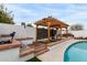 Beautifully designed pergola with wooden decking and surrounding brickwork, adjacent to the pool at 2744 E Windrose Dr, Phoenix, AZ 85032