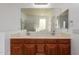 Bright bathroom featuring double sinks, vanity with wood cabinets, and a large mirror at 3127 W Apollo Rd, Phoenix, AZ 85041