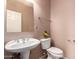 Powder room featuring a pedestal sink, mirror and toilet with neutral-colored walls at 3127 W Apollo Rd, Phoenix, AZ 85041