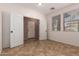 Well-lit bedroom featuring double doors, tile floors and neutral-colored walls at 3127 W Apollo Rd, Phoenix, AZ 85041