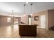 Open-concept kitchen featuring tile floors, a center island, modern lighting and neutral-colored walls at 3127 W Apollo Rd, Phoenix, AZ 85041