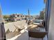 Inviting balcony seating area with comfortable chairs and an umbrella overlooking lush community homes at 3131 E Legacy Dr # 2105, Phoenix, AZ 85042