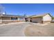 Residential home with a long driveway, solar panels, and tan exterior at 3210 W Belmont Ave, Phoenix, AZ 85051