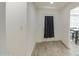 Bright hallway featuring tile flooring and white walls with a door leading outside at 3210 W Belmont Ave, Phoenix, AZ 85051