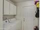 Well-lit laundry room with white brick walls, storage, and a doorway at 3210 W Belmont Ave, Phoenix, AZ 85051