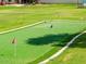 Manicured putting green with flags, and lush landscaping for practicing your short game at 3330 E Main St # 323, Mesa, AZ 85213