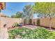 Private backyard featuring artificial turf, mature trees, a water feature, and a brick wall for added seclusion at 3443 S California St, Chandler, AZ 85248