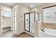 Bathroom featuring a sleek glass-enclosed shower, bathtub and walk-in closet access at 3443 S California St, Chandler, AZ 85248