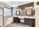 Elegant bathroom with dual vanities, soaking tub, decorative wall, and neutral tile floors at 3443 S California St, Chandler, AZ 85248