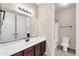 Bathroom with a large mirror above a white counter and dark wood cabinets at 3443 S California St, Chandler, AZ 85248