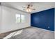 Bright bedroom features neutral carpet, a ceiling fan, and a large window overlooking trees at 3443 S California St, Chandler, AZ 85248