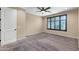 Empty bedroom featuring plush carpet, ceiling fan and a sunlit window with dark shutters at 3443 S California St, Chandler, AZ 85248