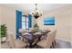 Dining room featuring elegant table setting, chandelier, and bright blue curtains at 3443 S California St, Chandler, AZ 85248