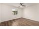 Bright bedroom features hardwood floors, a ceiling fan, and a window with a street view at 3707 E Amelia Ave, Phoenix, AZ 85018